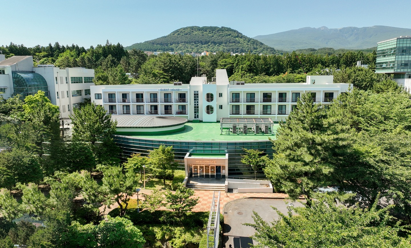 Wide front view of ARA Convention Hall surrounded by trees